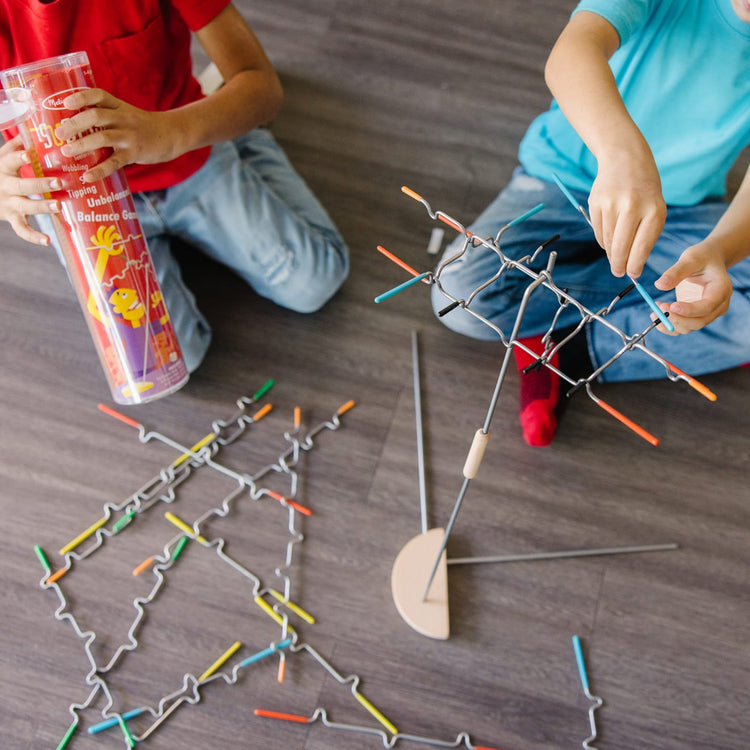 A kid playing with the Melissa & Doug Suspend Family Game (31 pcs)