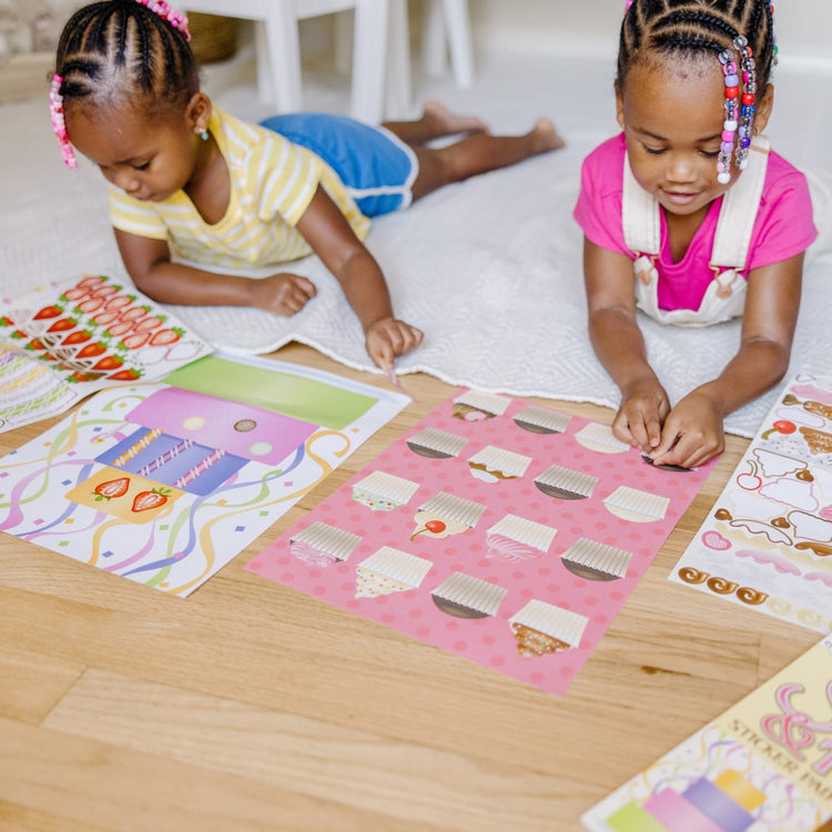 A kid playing with the Melissa & Doug Sweets and Treats Sticker Pad - 500 Stickers, 16 Backgrounds