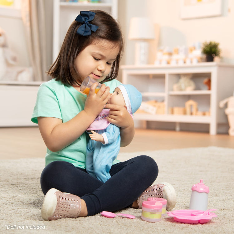 A kid playing with the Melissa & Doug Mine to Love Baby Food & Bottle Play Set