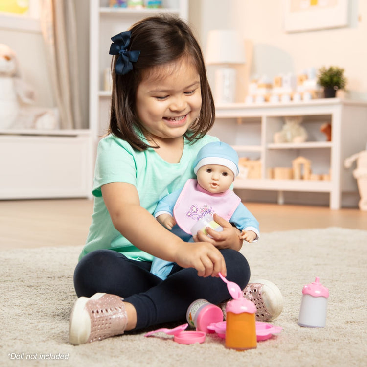 A kid playing with the Melissa & Doug Mine to Love Baby Food & Bottle Play Set