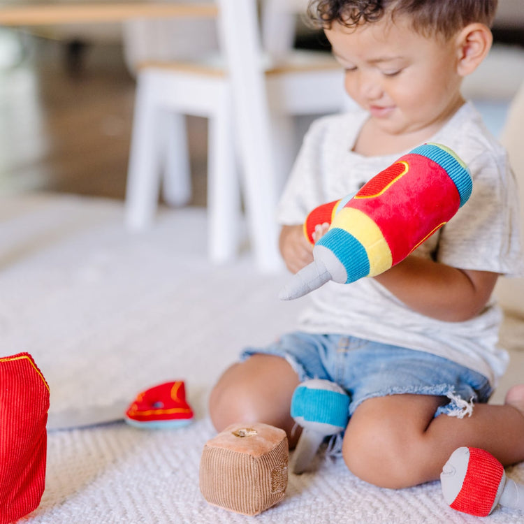 A kid playing with the Melissa & Doug Toolbox Fill and Spill Toddler Toy With Vibrating Drill  (9 pcs)