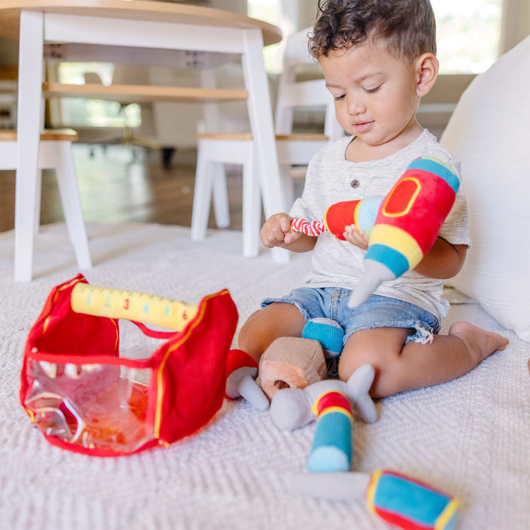 A kid playing with the Melissa & Doug Toolbox Fill and Spill Toddler Toy With Vibrating Drill  (9 pcs)