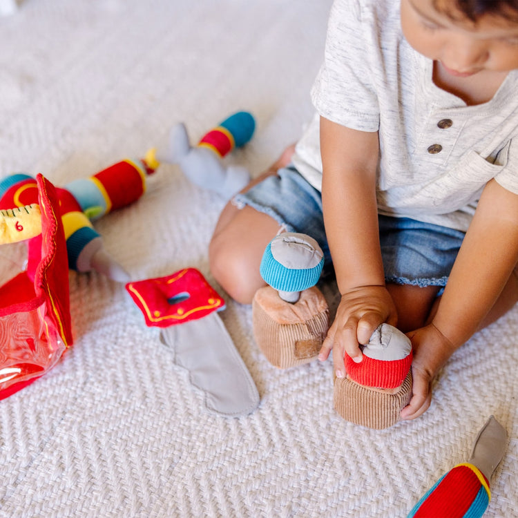 A kid playing with the Melissa & Doug Toolbox Fill and Spill Toddler Toy With Vibrating Drill  (9 pcs)