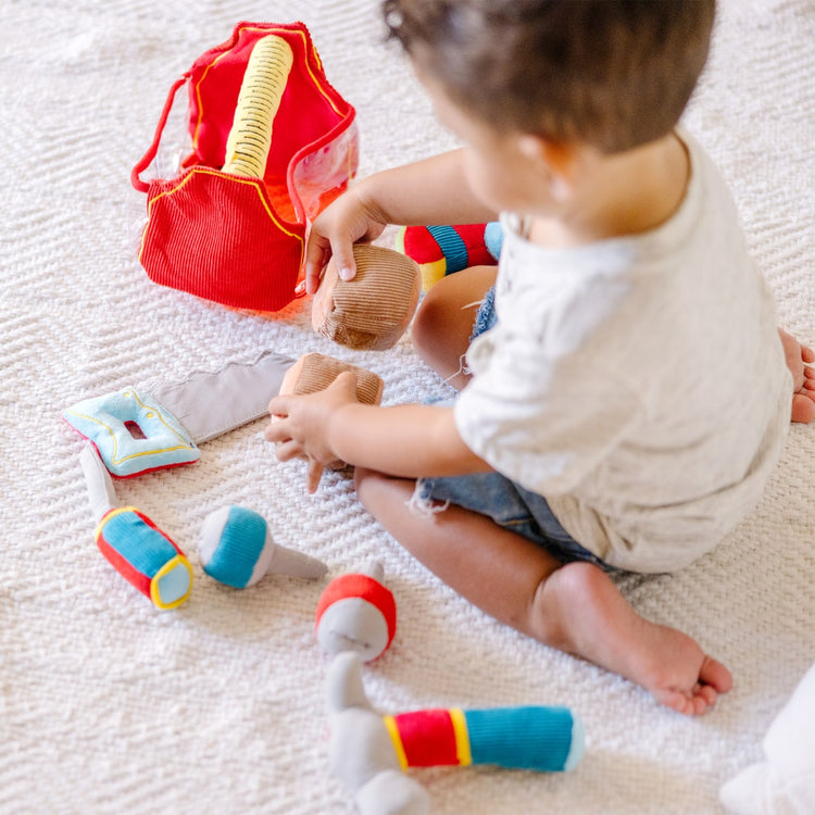 A kid playing with the Melissa & Doug Toolbox Fill and Spill Toddler Toy With Vibrating Drill  (9 pcs)