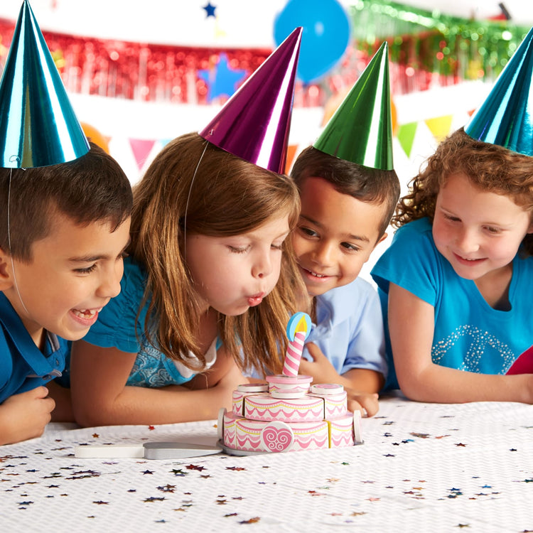 A kid playing with the Melissa & Doug Triple-Layer Party Cake Wooden Play Food Set