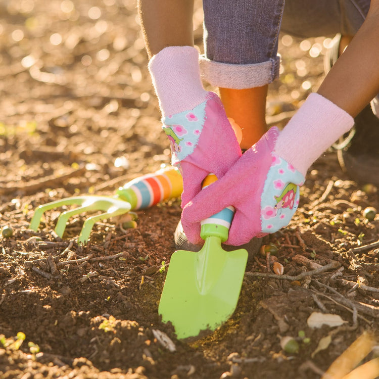 A kid playing with the Melissa & Doug Dixie and Trixie Ladybug Good Gripping Gardening Gloves