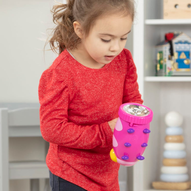 A kid playing with the Melissa & Doug Sunny Patch Trixie Ladybug Flashlight With Easy-Grip Handle