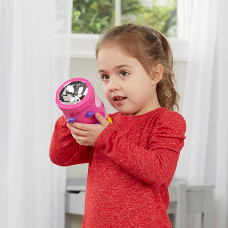 A kid playing with the Melissa & Doug Sunny Patch Trixie Ladybug Flashlight With Easy-Grip Handle