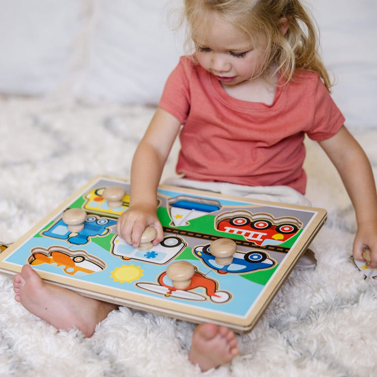 A kid playing with the Melissa & Doug Vehicles Jumbo Knob Wooden Puzzle (8 pcs)