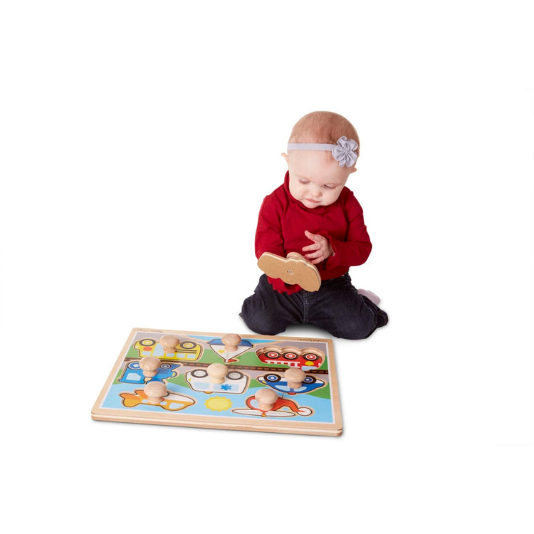 A child on white background with the Melissa & Doug Vehicles Jumbo Knob Wooden Puzzle (8 pcs)