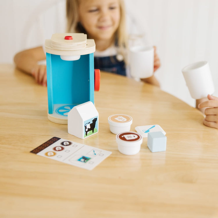 A kid playing with the Melissa & Doug 11-Piece Brew and Serve Wooden Coffee Maker Set - Play Kitchen Accessories