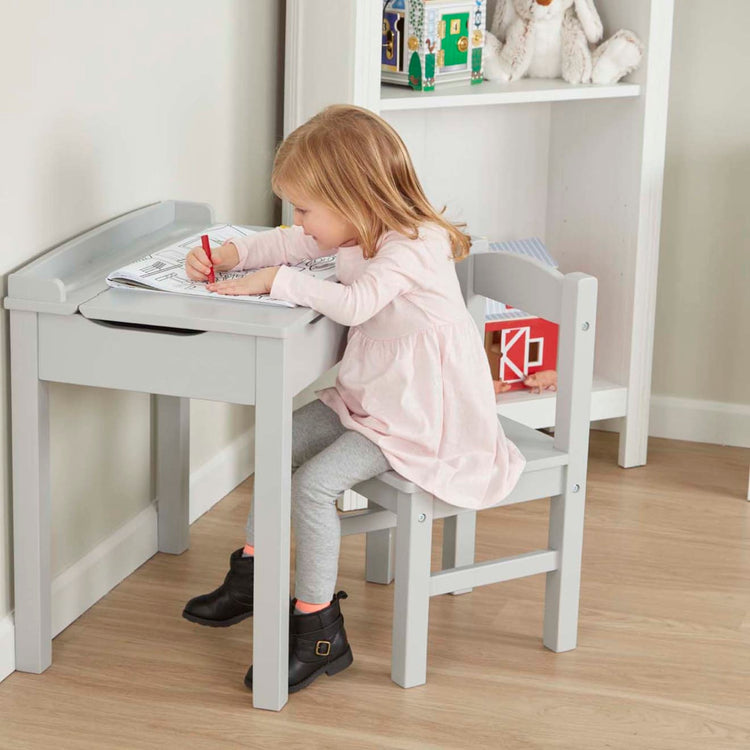 A kid playing with the Wooden Lift-Top Desk & Chair - Gray