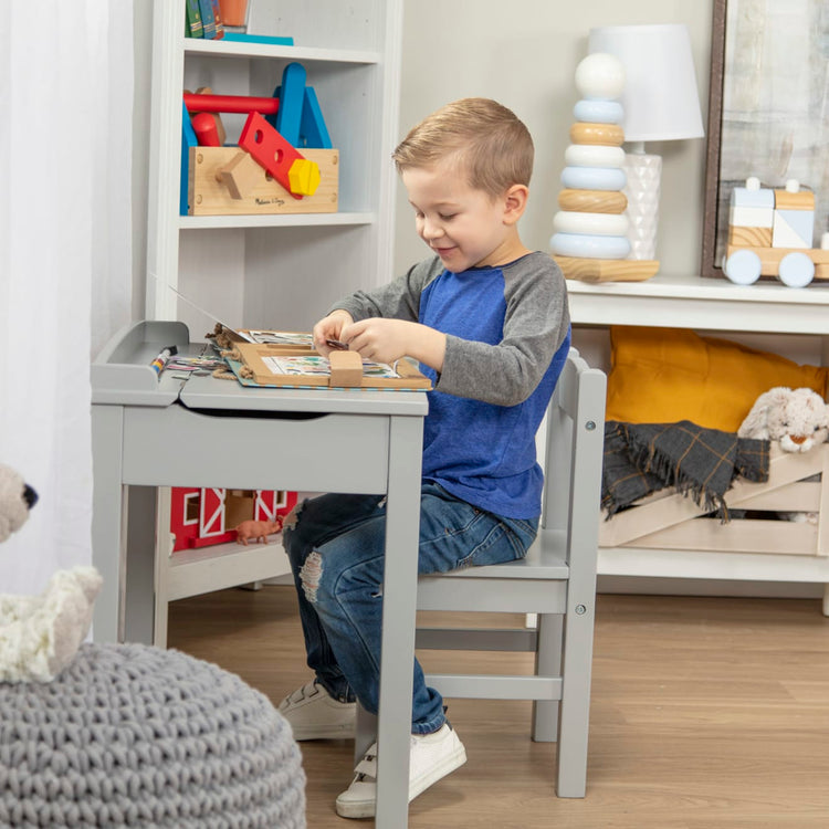 A kid playing with the Wooden Lift-Top Desk & Chair - Gray