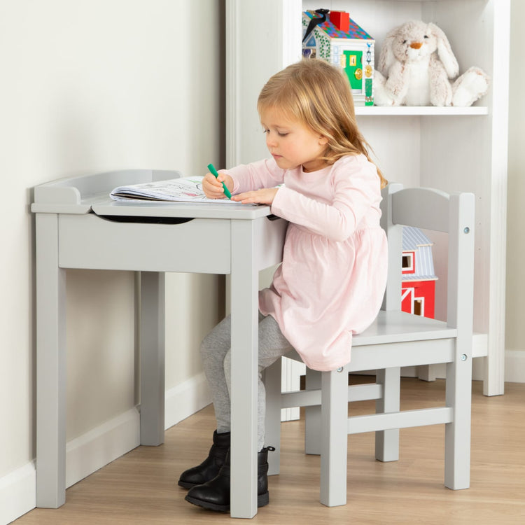 A kid playing with the Wooden Lift-Top Desk & Chair - Gray