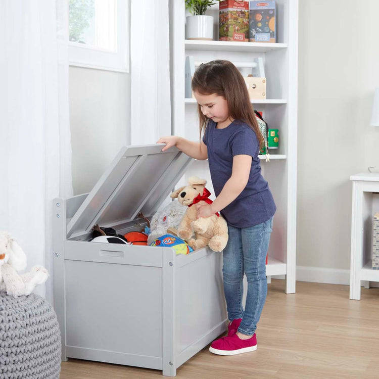 A kid playing with the Melissa & Doug Wooden Toy Chest (Gray)