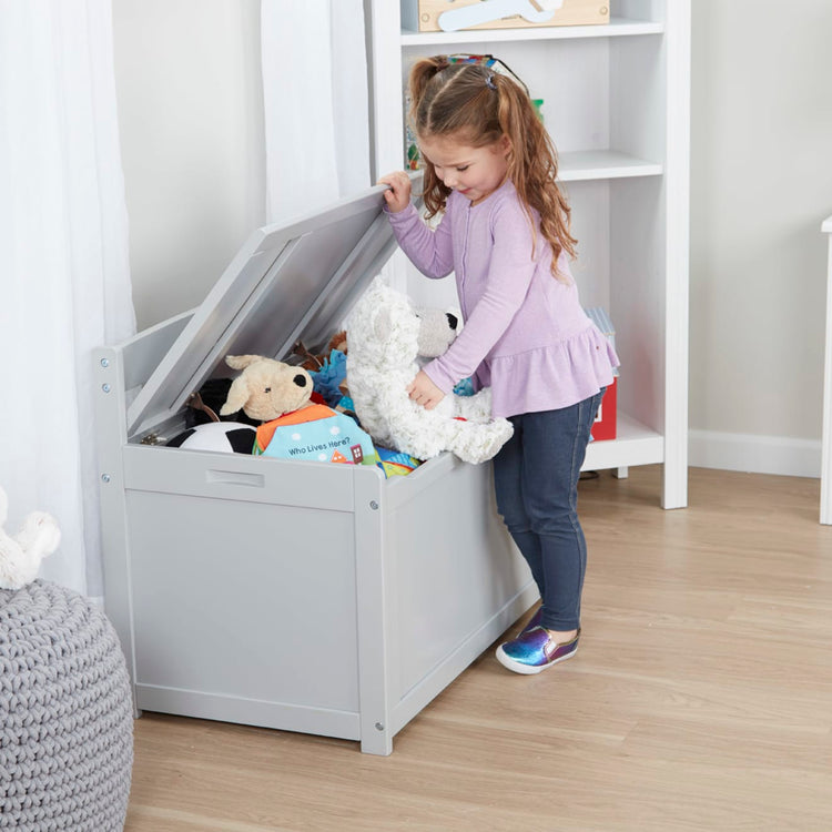 A kid playing with the Melissa & Doug Wooden Toy Chest (Gray)