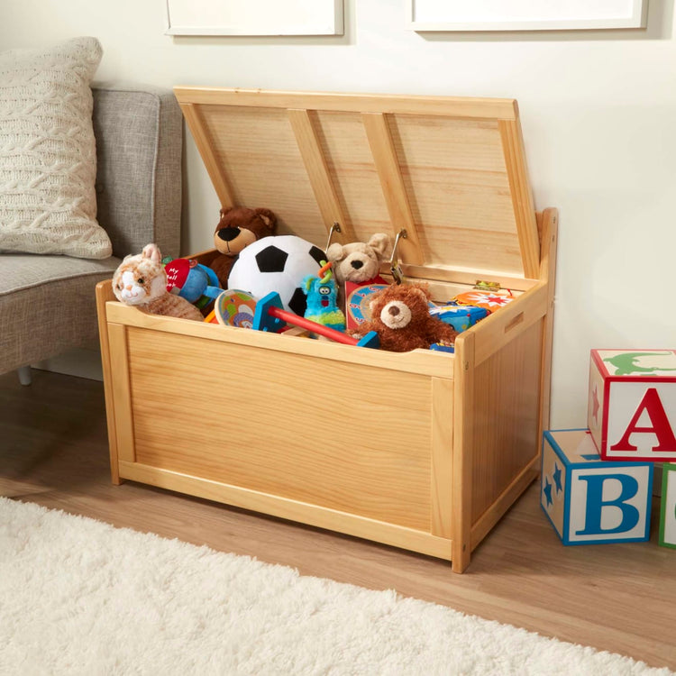 A kid playing with the Melissa & Doug Wooden Toy Chest (Honey)