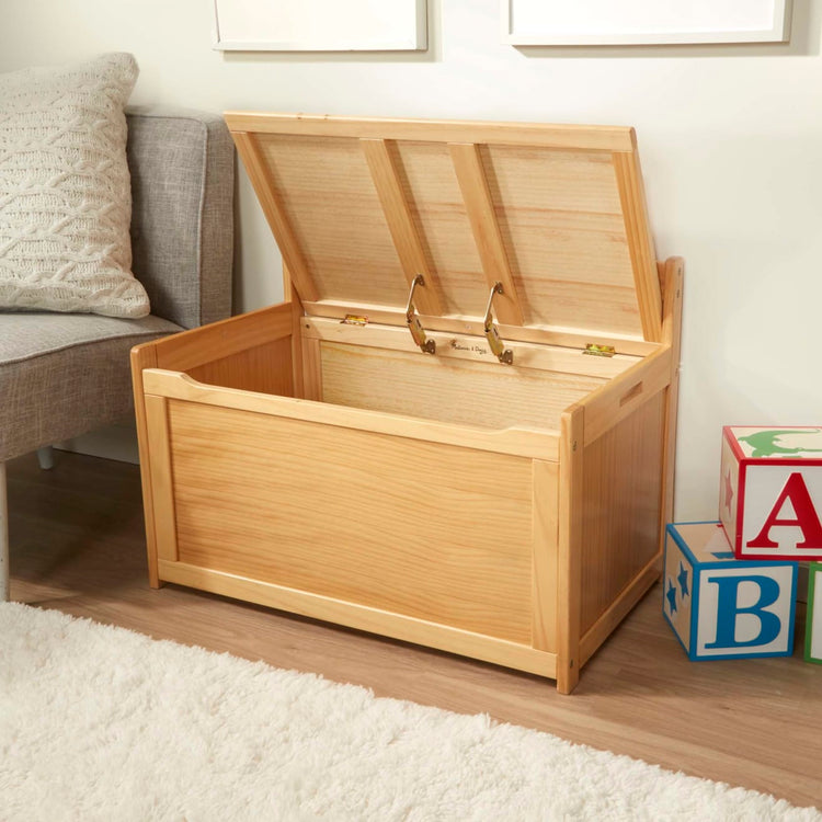 A kid playing with the Melissa & Doug Wooden Toy Chest (Honey)