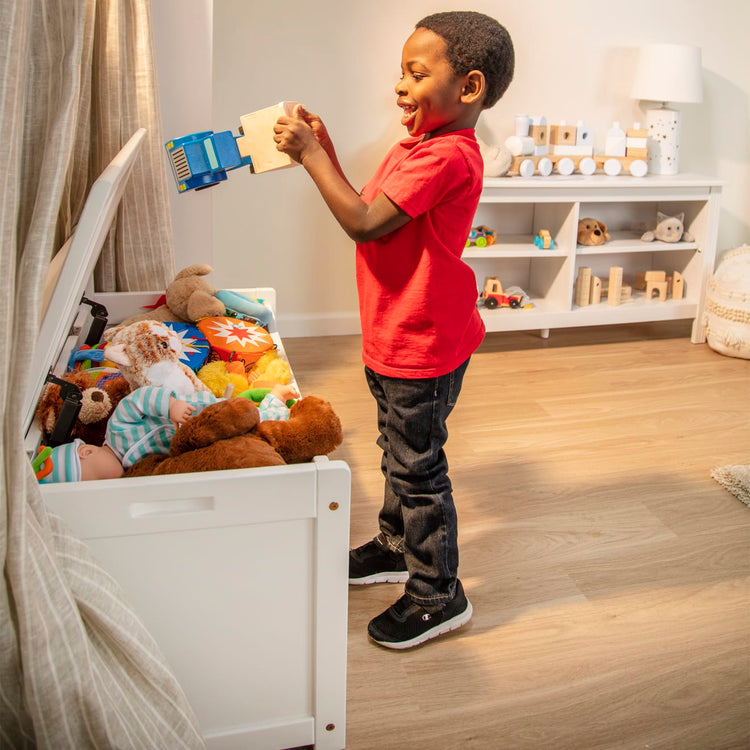 A kid playing with the Melissa & Doug Wooden Toy Chest (White)