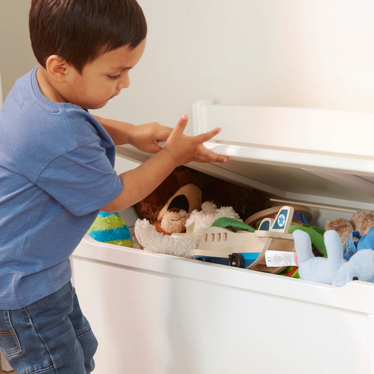 A kid playing with the Melissa & Doug Wooden Toy Chest (White)